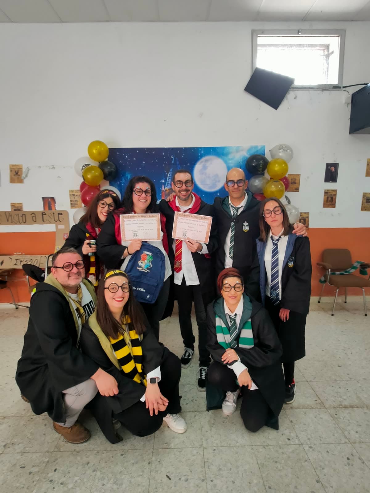 Grupo de adultos disfrazados de magos con sus diplomas en una fiesta temática
