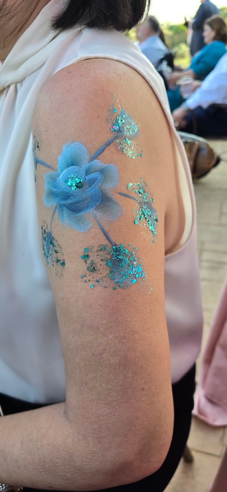 Diseño de flores azules pintado en el brazo con técnica One Stroke