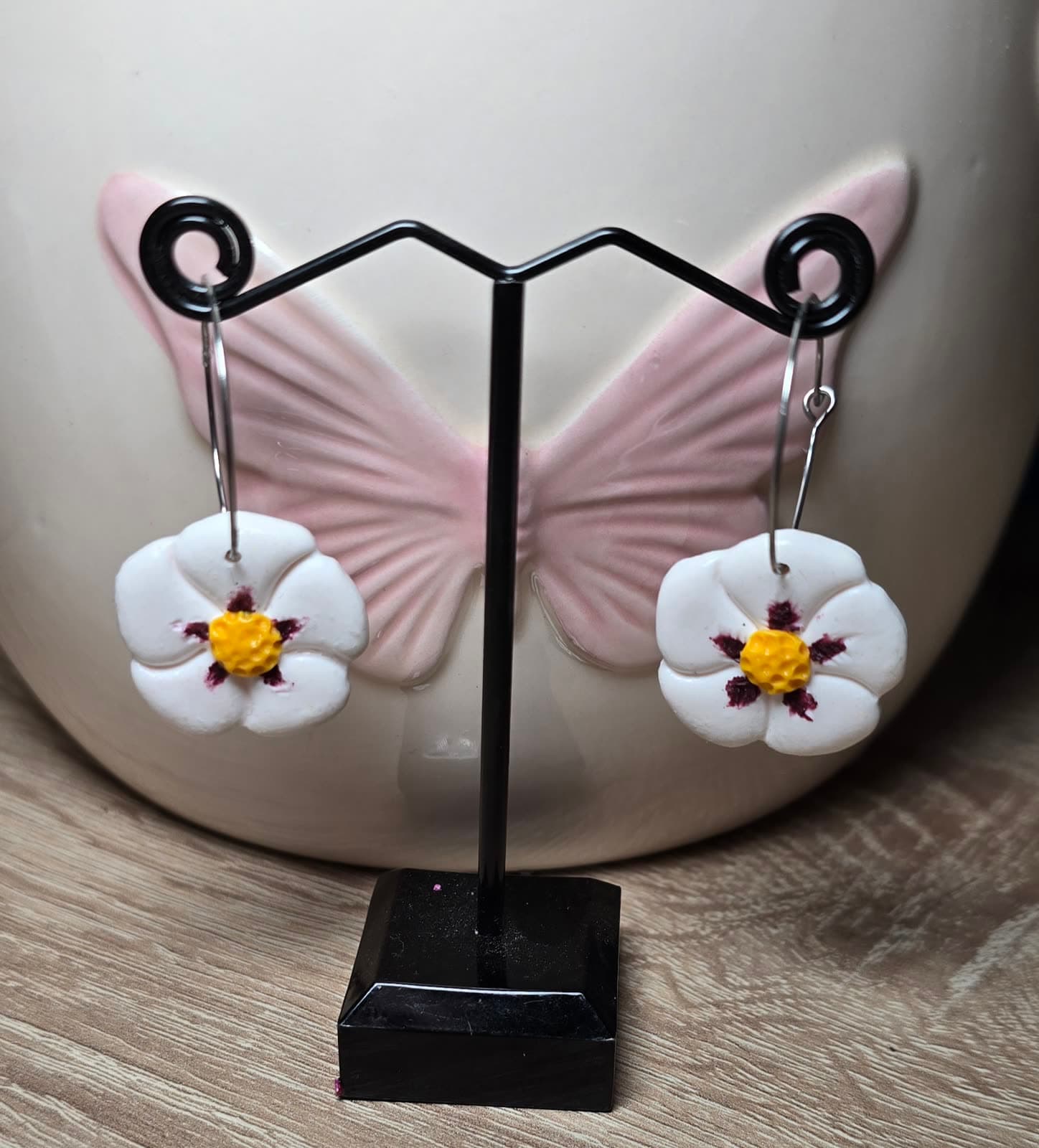 Pendientes artesanales con flor de jara blanca en un expositor
